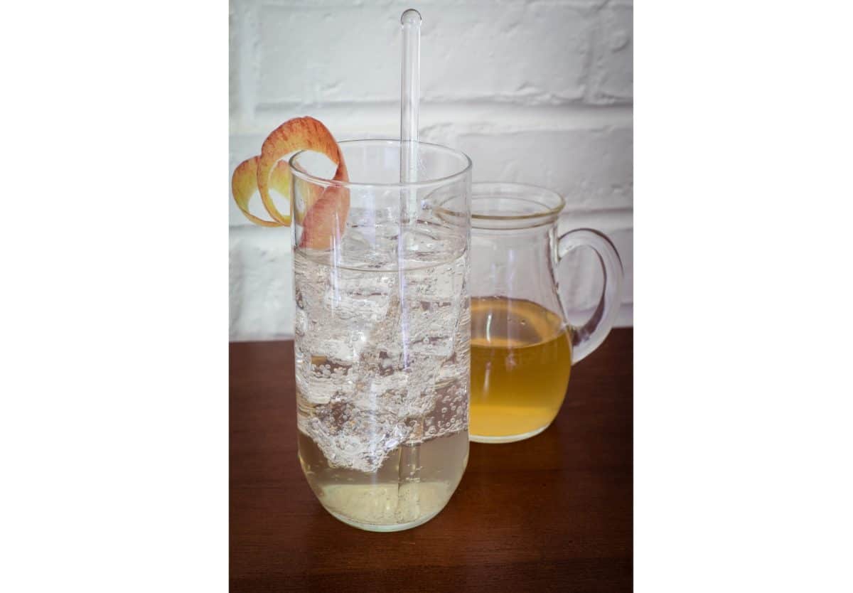 Clear pitcher and glass filled with Apple Spiced Simple Syrup