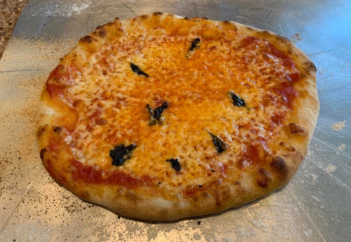 A freshly baked Margherita pizza with melted cheese and basil leaves.