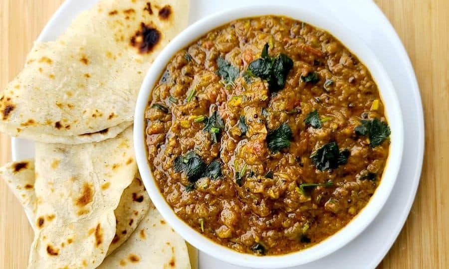 Overhead shot of Baingan Bharta (smoky eggplant) served with flatbread.