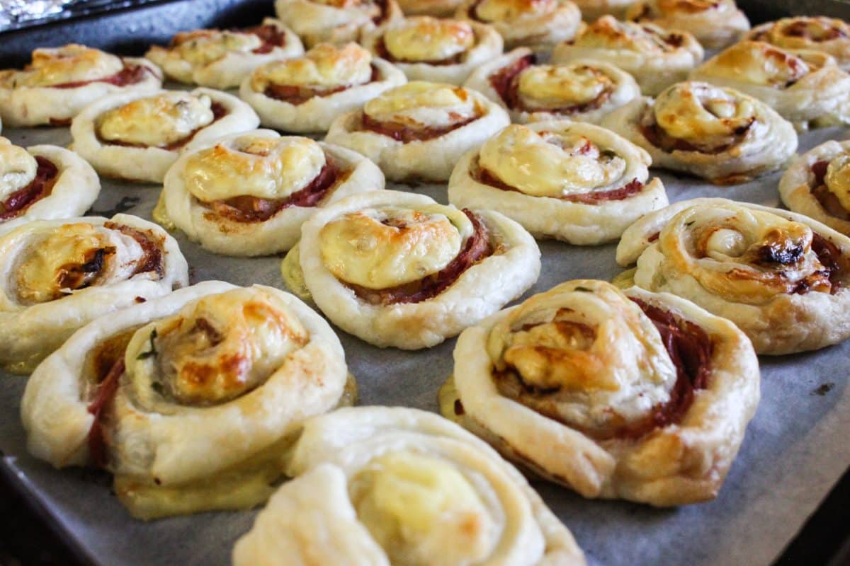 Golden baked puff pastry pinwheels with cheese and meat fillings.