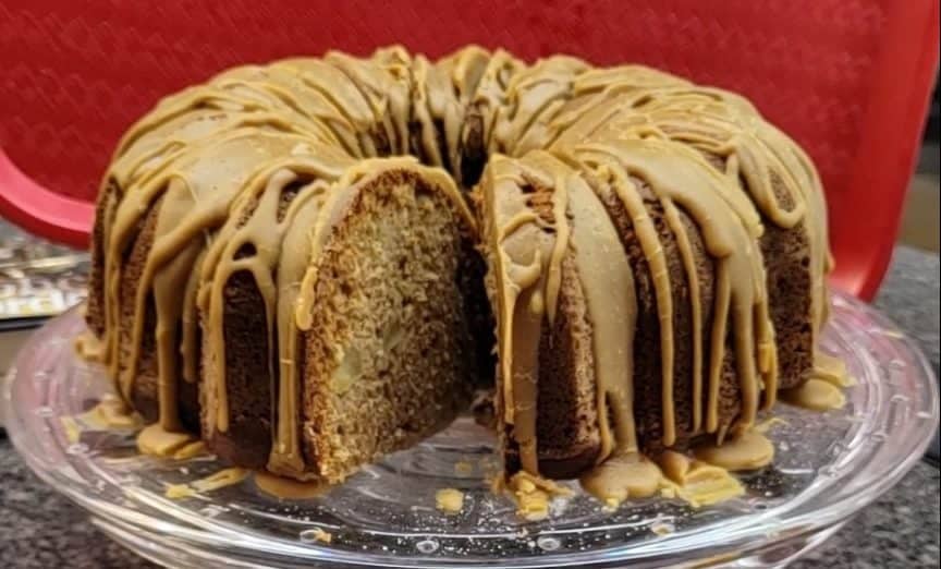 Sliced apple cake with sea salted caramel glaze on a glass plate.
