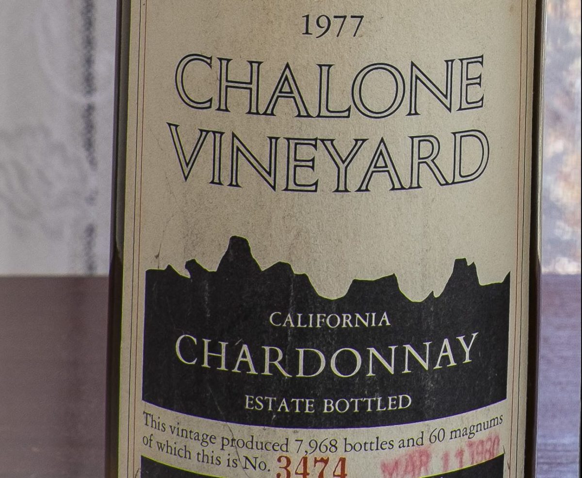 Close-up view of the label on a 1977 Chalone Chardonnay Estate wine bottle.
