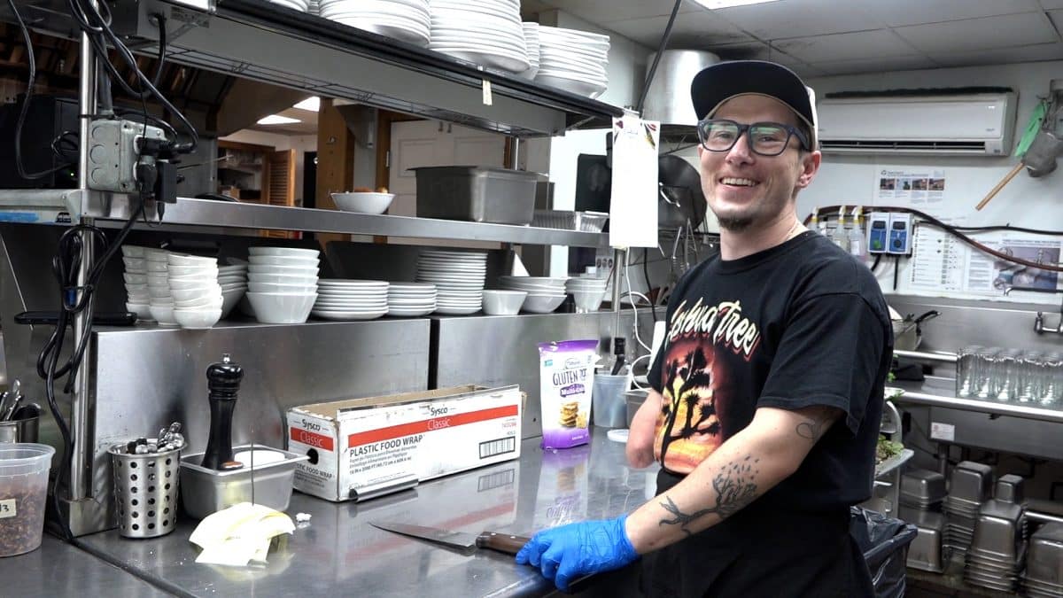 Chef Michael smiling in the kitchen with tattooed left arm