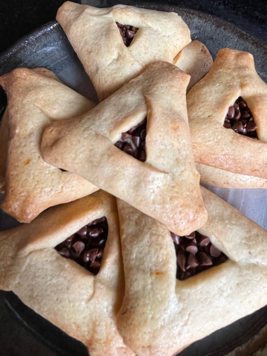 Freshly baked hamantaschen with chocolate chip fillings peeking out.