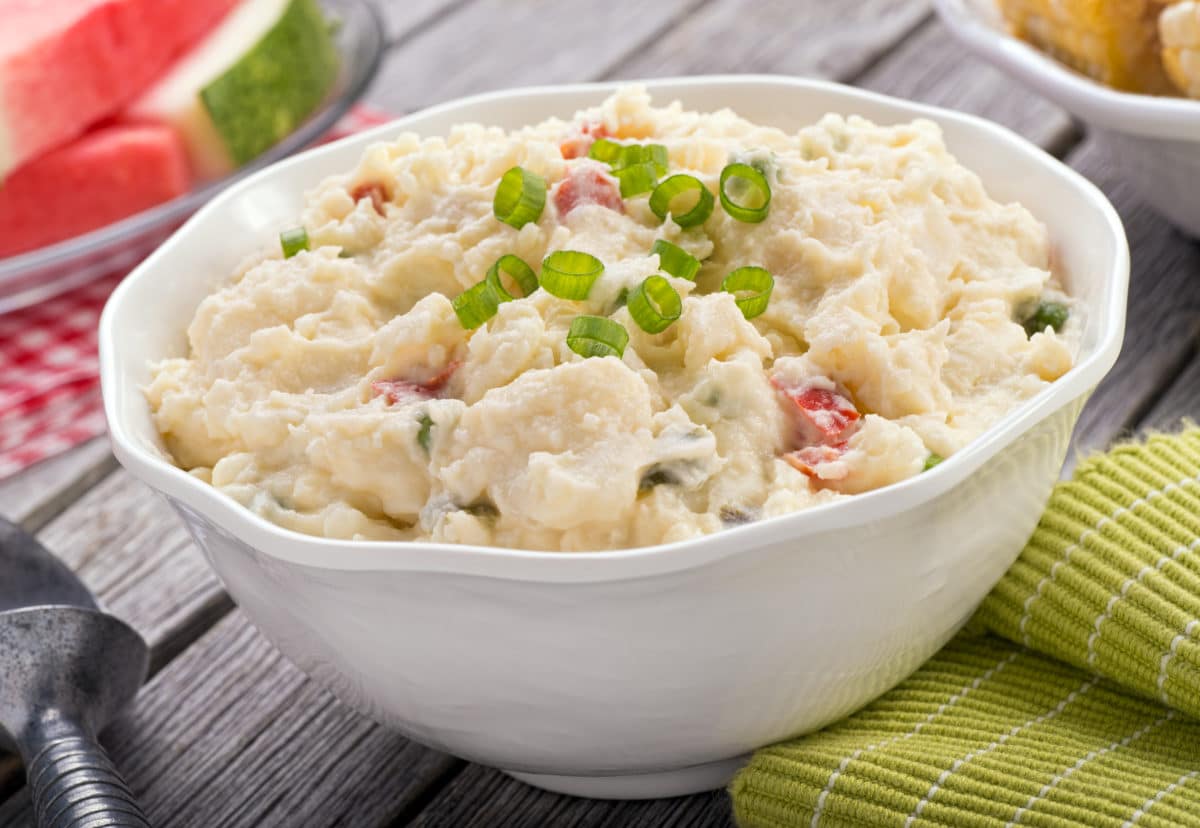 Creamy potato salad garnished with fresh herbs