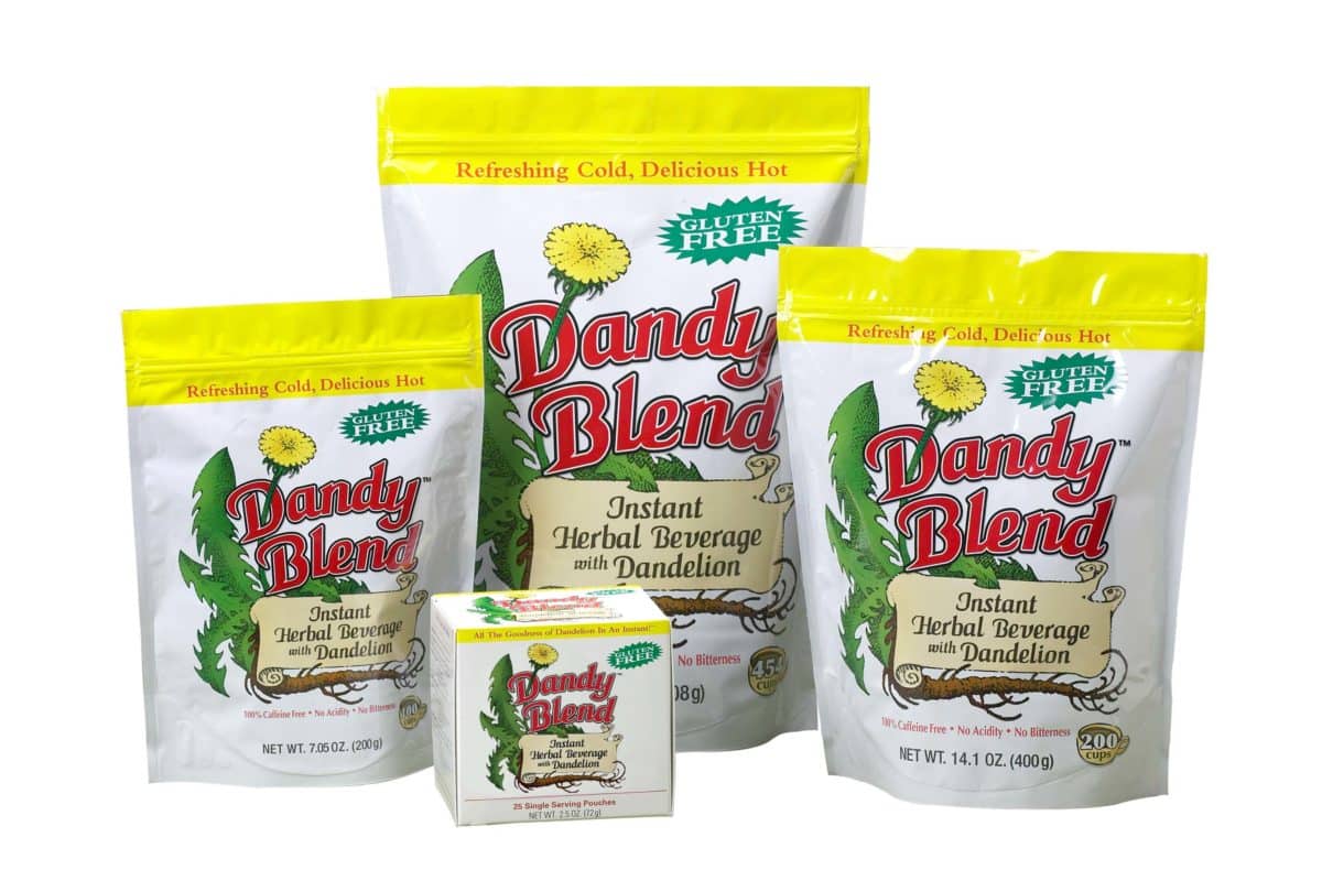 Three packages of Dandy Blend Instant Herbal Beverage with Dandelion on a grassy backdrop.