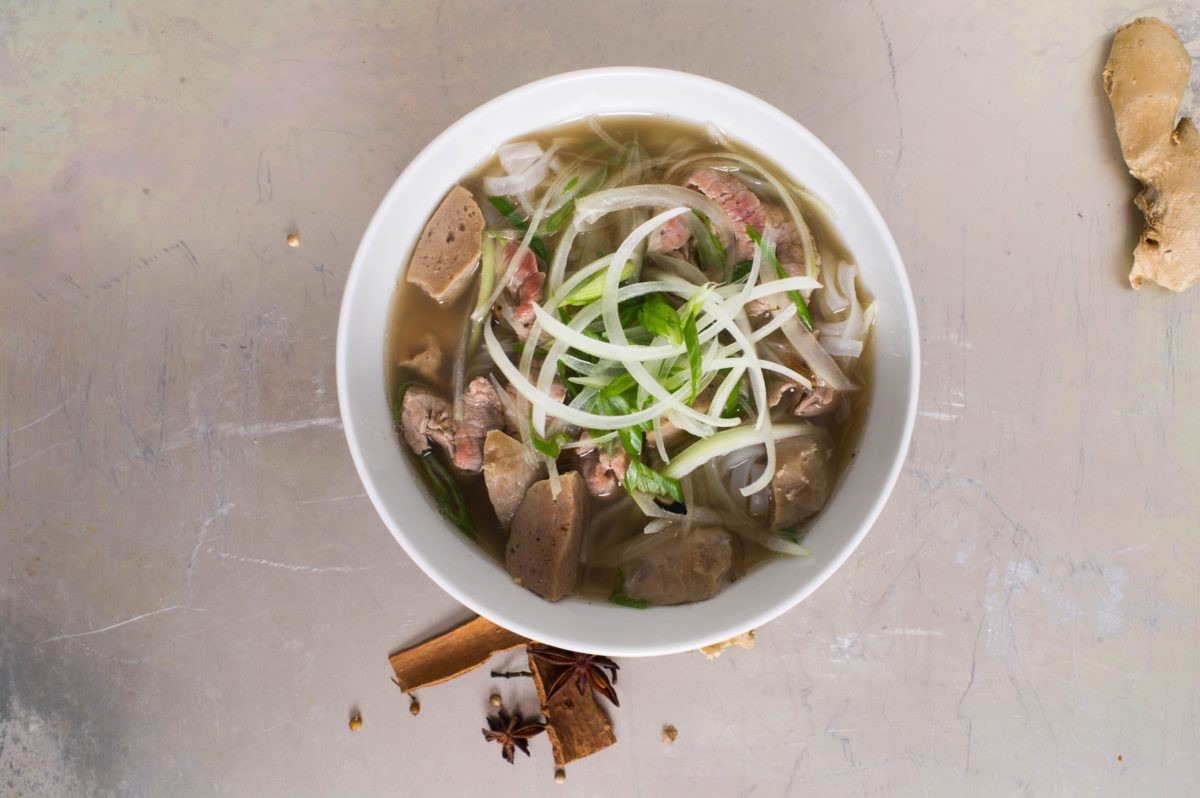 Close-up view of a pho dish garnished with fresh ingredients