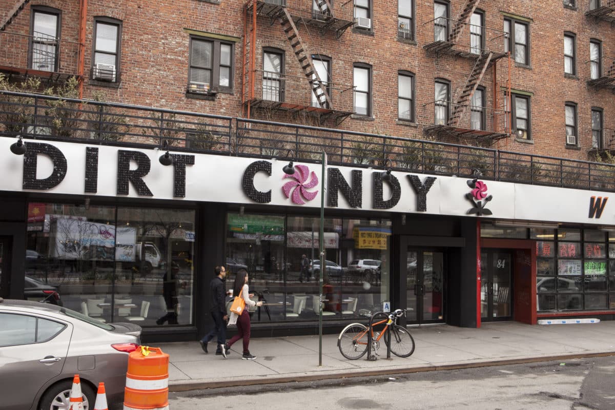 Exterior view of Dirt Candy restaurant in New York with people passing by