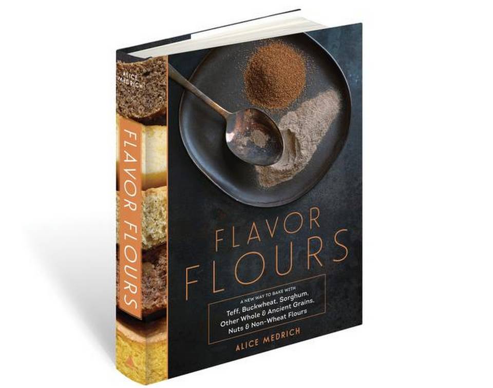 The cover of the "Flavor Flours" book by Alice Medrich, featuring an image of a spoon and various flours.