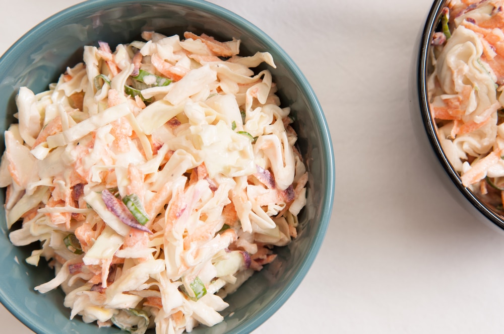 Bowl of homemade coleslaw, freshly prepared using cabbage sourced from local farms.