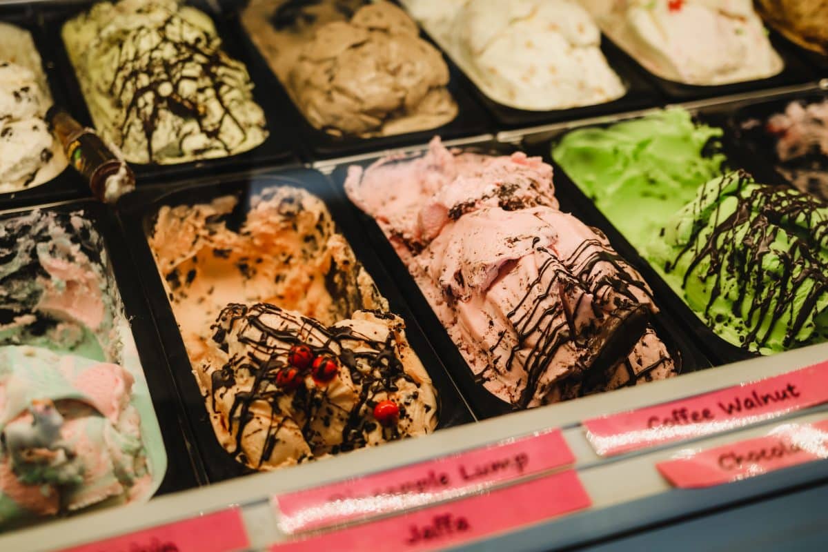 Close-up of various gelato flavors in a display case with labels.