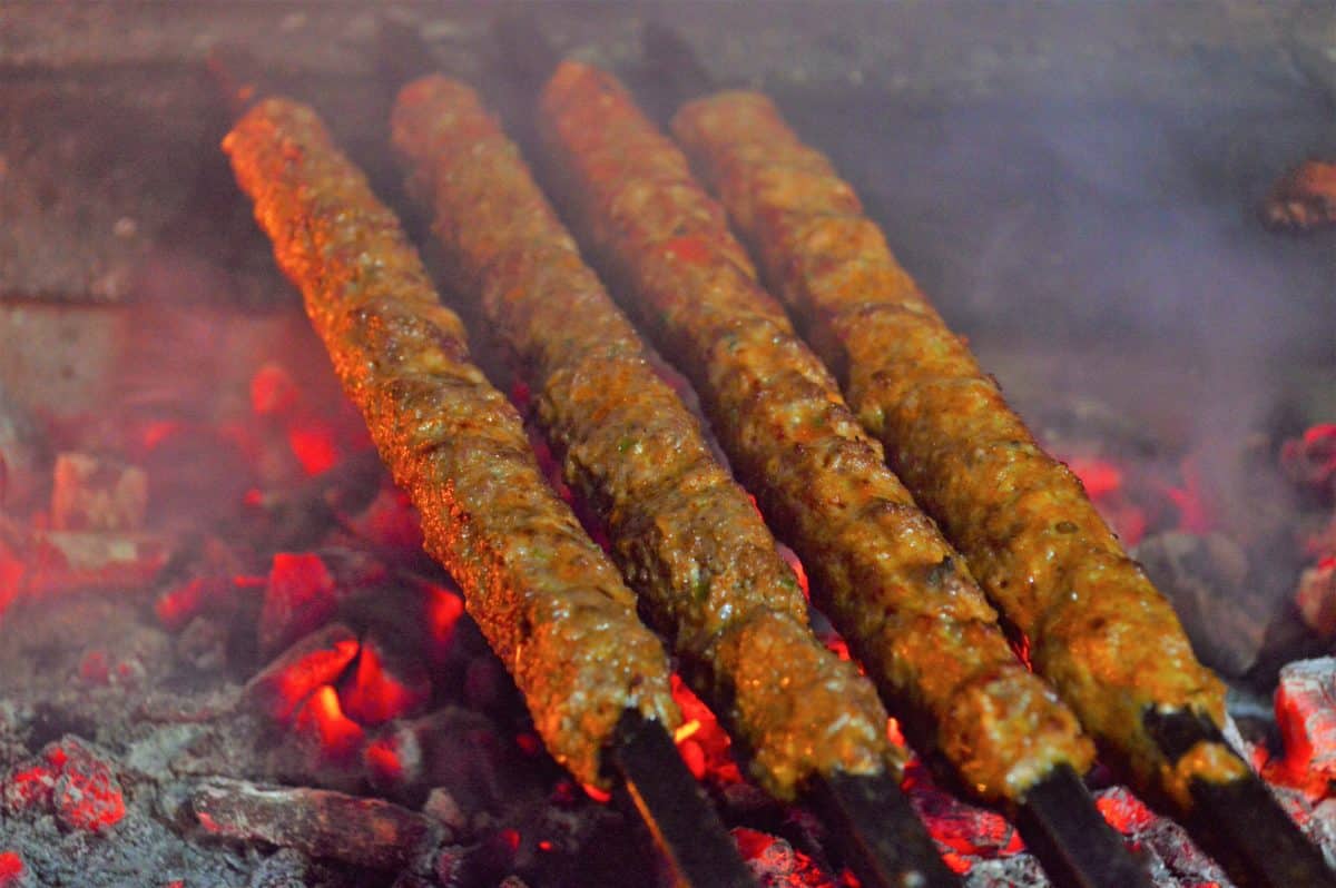 Tandoori Seekh Kebabs grilling over glowing red charcoal