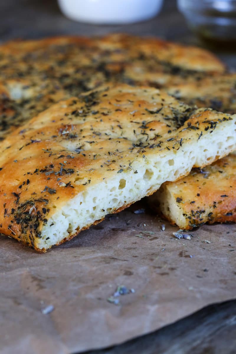 A close-up shot of gluten-free focaccia bread seasoned with herbs.