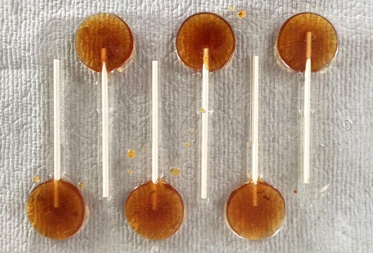 Rows of amber-colored lollipops infused with hop flavor, known as Lollihops.