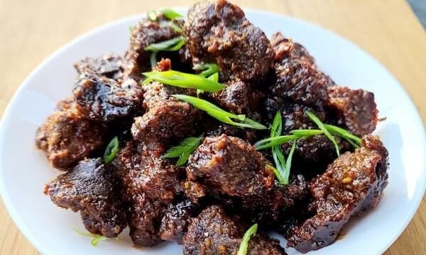 Korean BBQ Burnt Ends on a plate garnished with sliced green onions