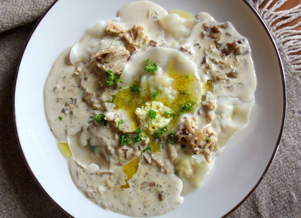 A plate of lobster shrimp mushroom ravioli in saffron butter sauce.