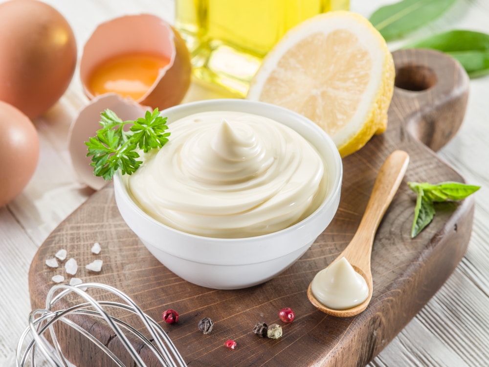 Ingredients for making mayonnaise including egg, lemon, and oil