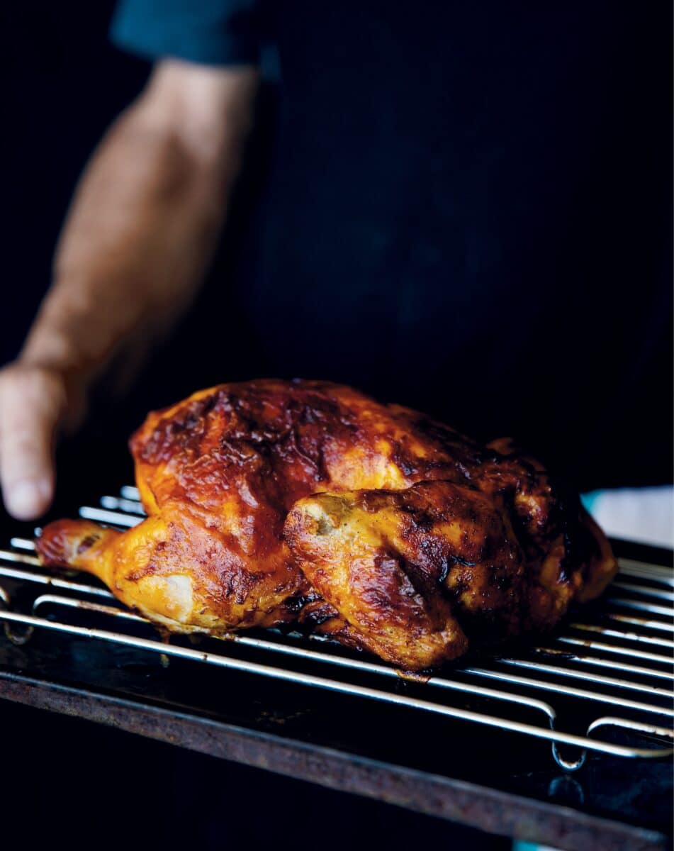 Grilled chicken with a savory glaze on a grill rack.