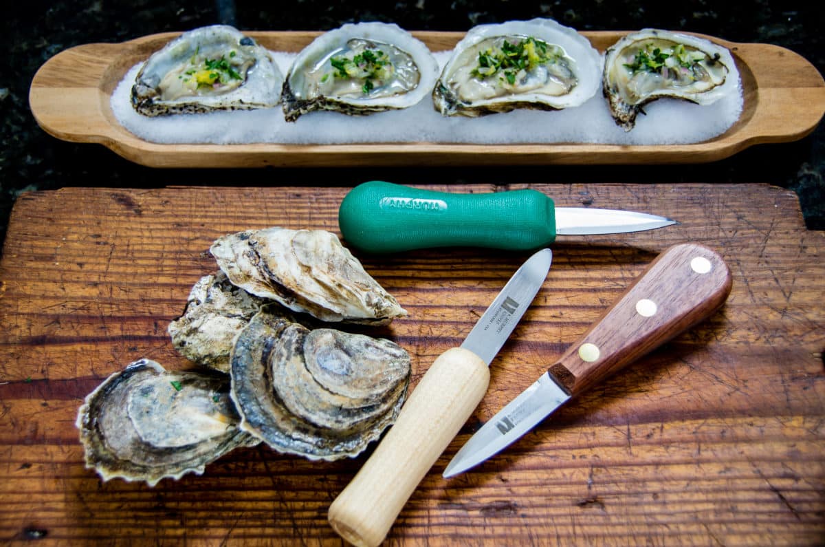 Oyster knives displayed on a wooden board
