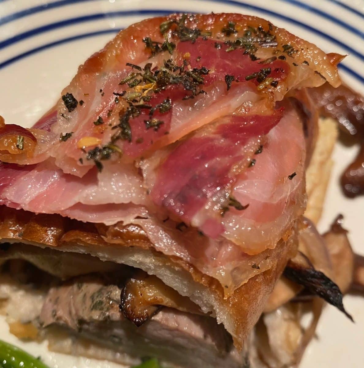 Succulent rolled pork topped with crisped pancetta.