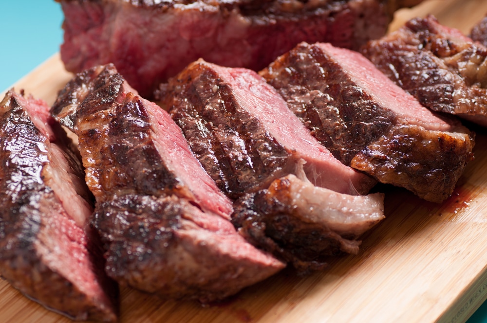 Juicy tomahawk steak seared to perfection, showcasing medium rare to rare doneness.