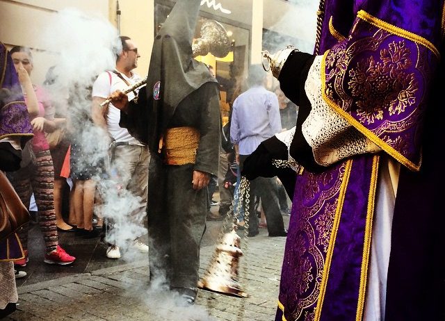 Members of a Semana Santa procession in traditional purple robes and hoods.