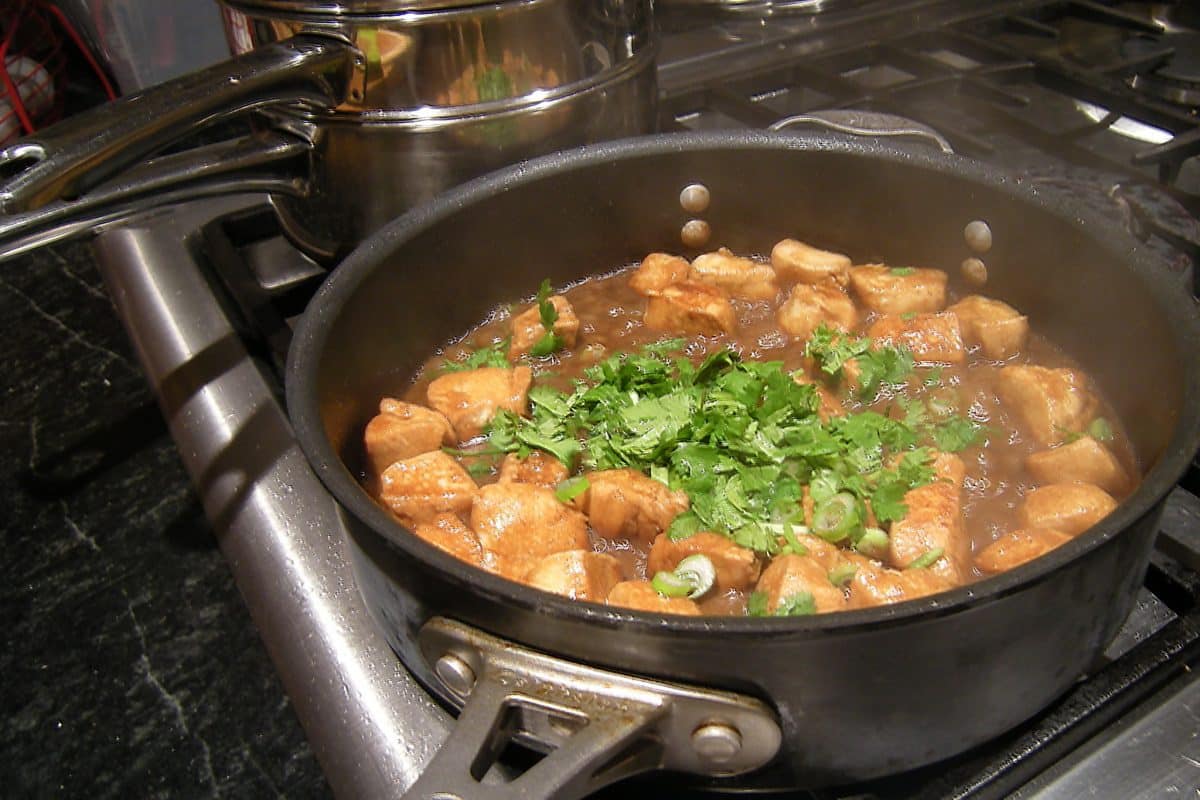 Delicious dish simmering in a saucepan, garnished with fresh cilantro.