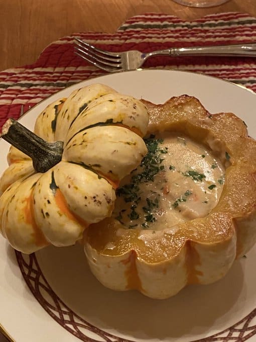 A dish showcasing a stuffed squash filled with creamy content.