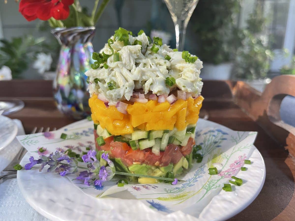 Layered crab and vegetable stack on a decorative plate