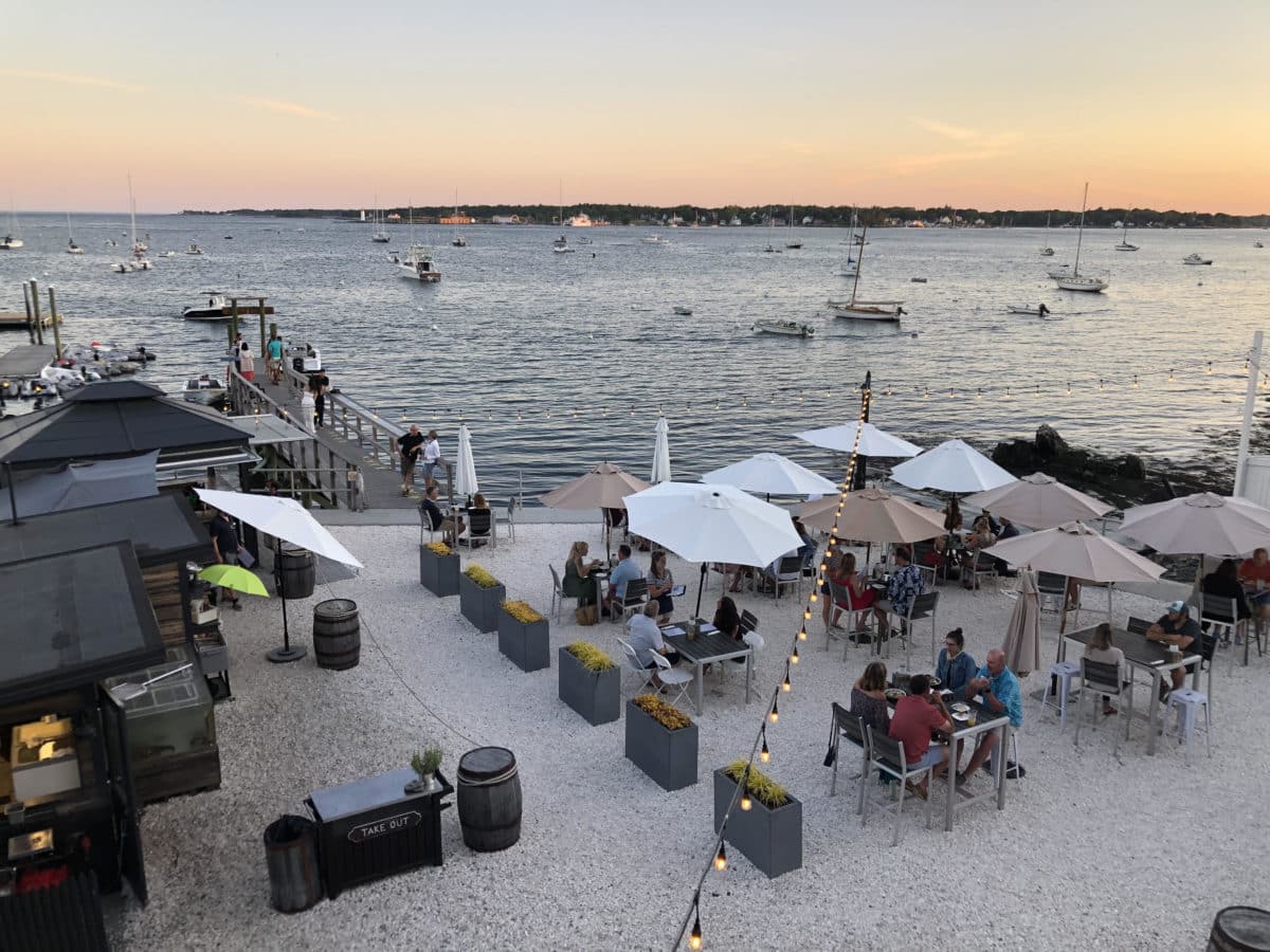 A picturesque sunset view over Pepperrell Cove with boats in the distance.