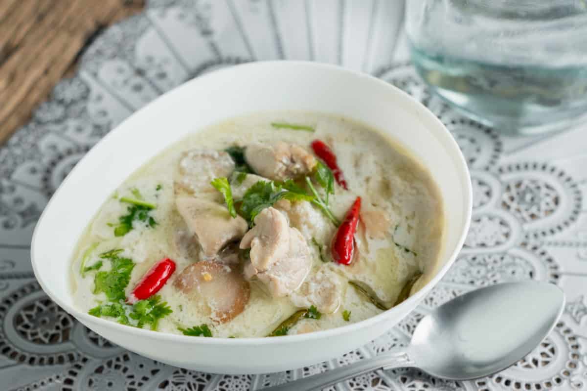 Close-up of tom kha gai soup with chicken and red chili
