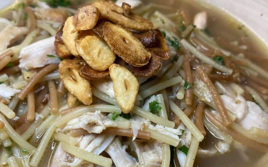 Warm Lebanese chicken noodle soup with thin noodles, chicken pieces, and crispy garnish.