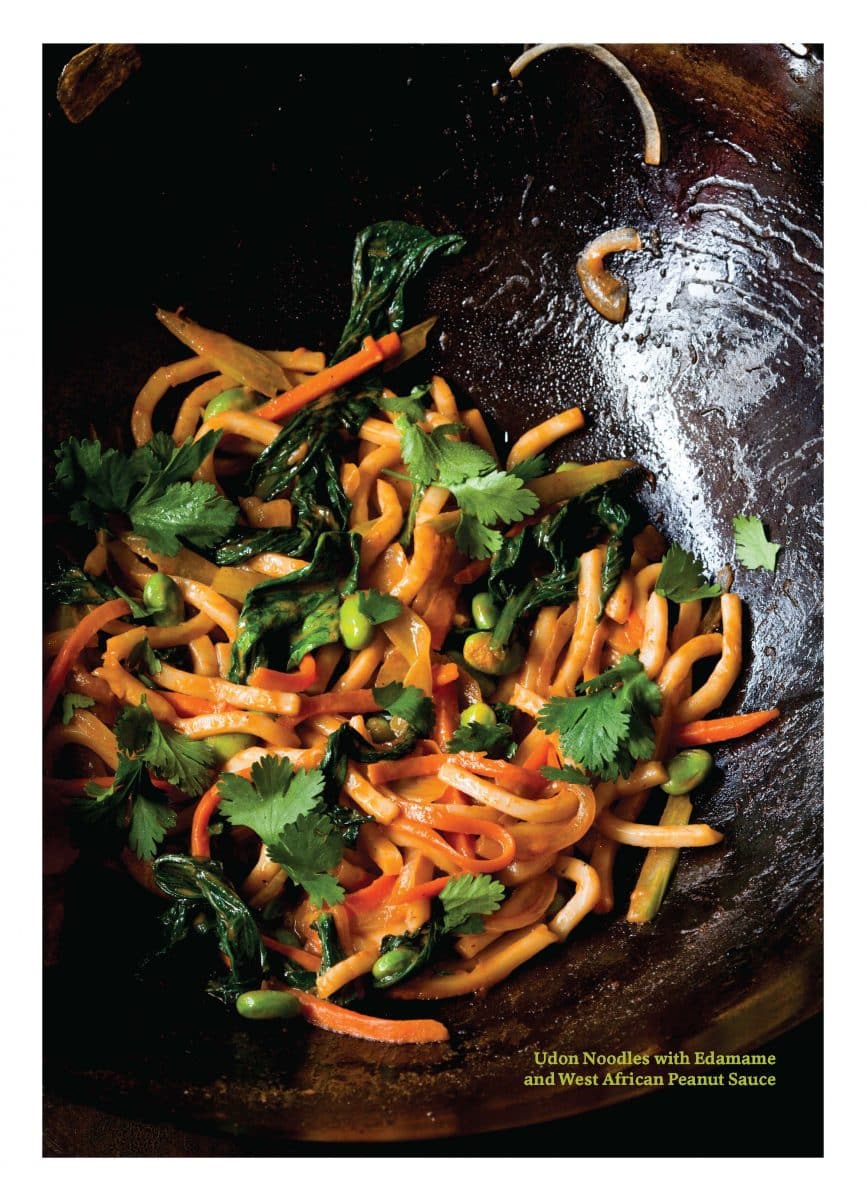Stir-fried udon noodles with edamame, veggies, and peanut sauce, garnished with cilantro.