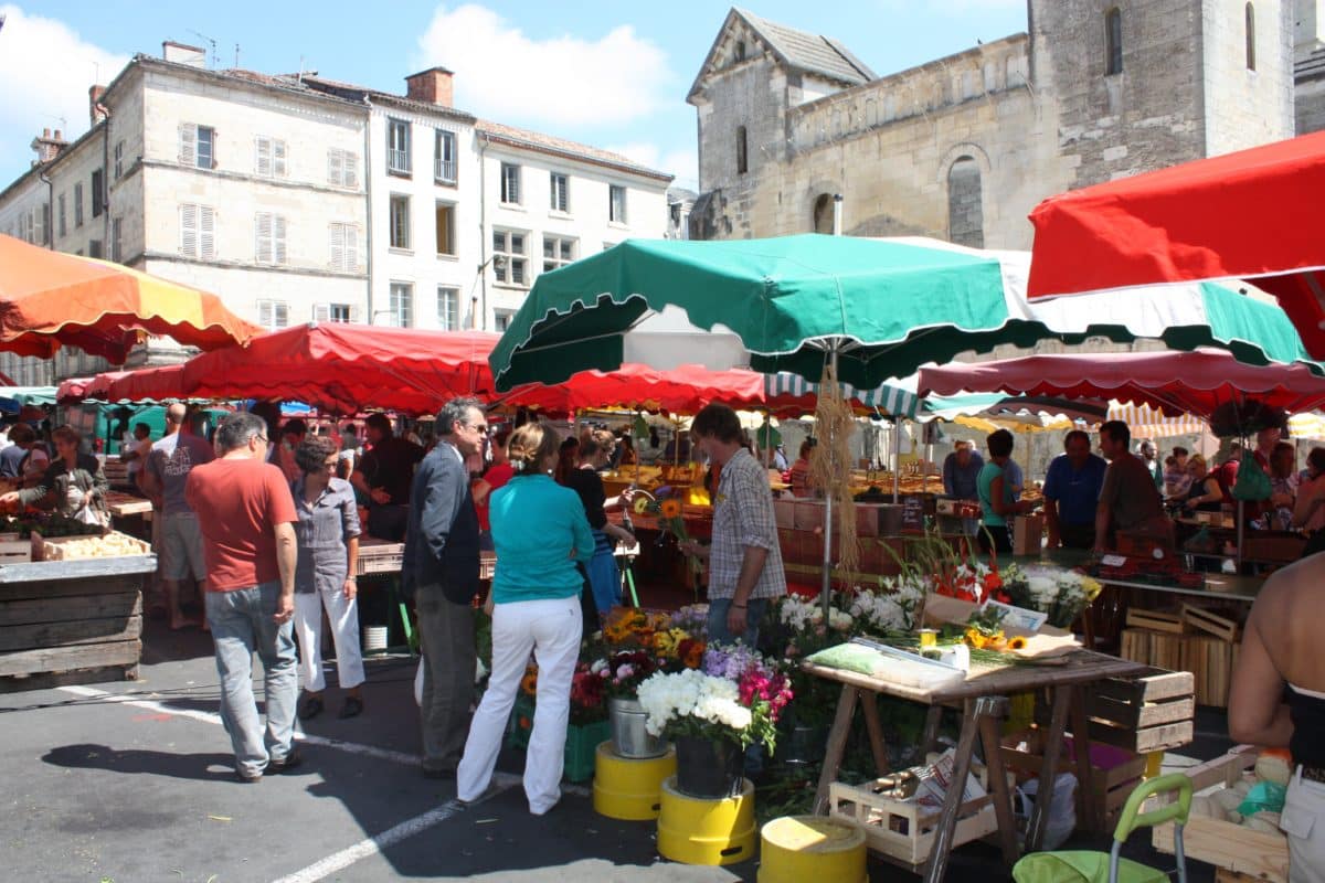 Bustling French market scene with colorful stalls and shoppers