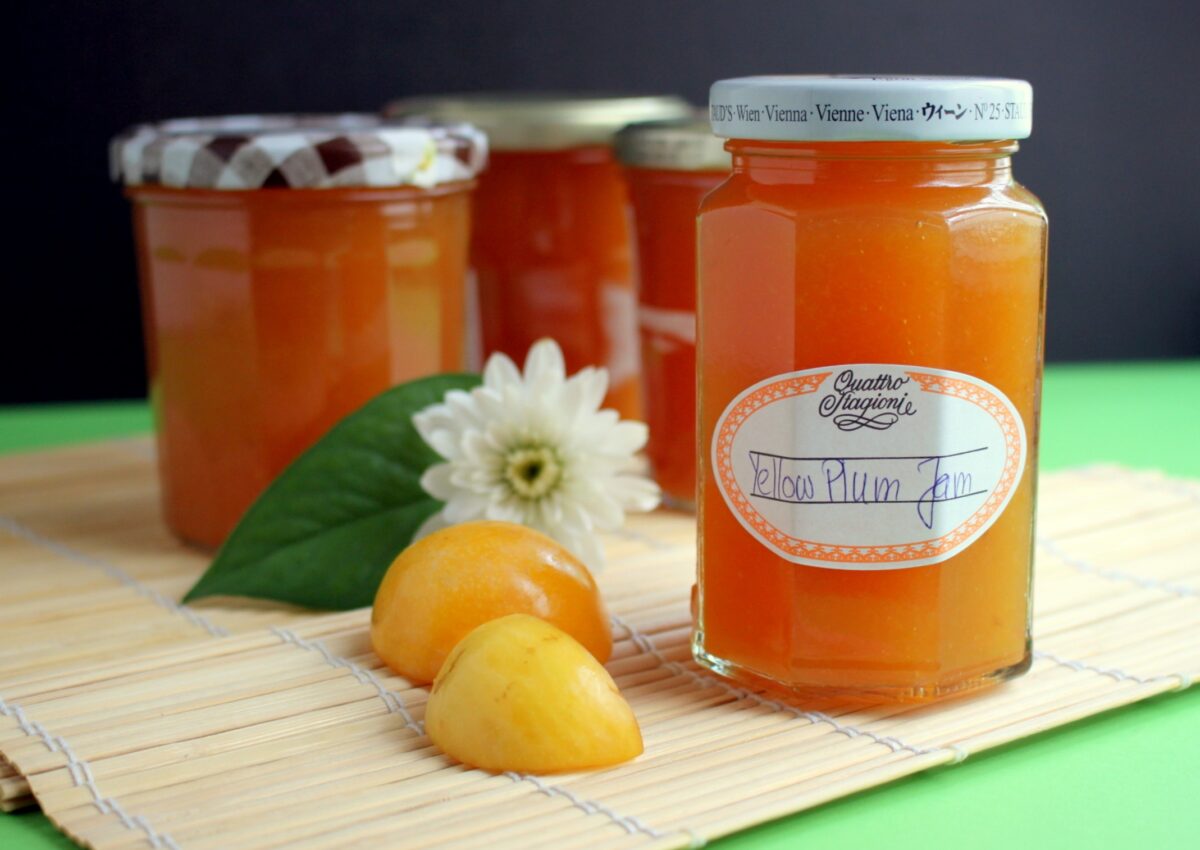 Several jars of yellow jam in containers that look re-used.