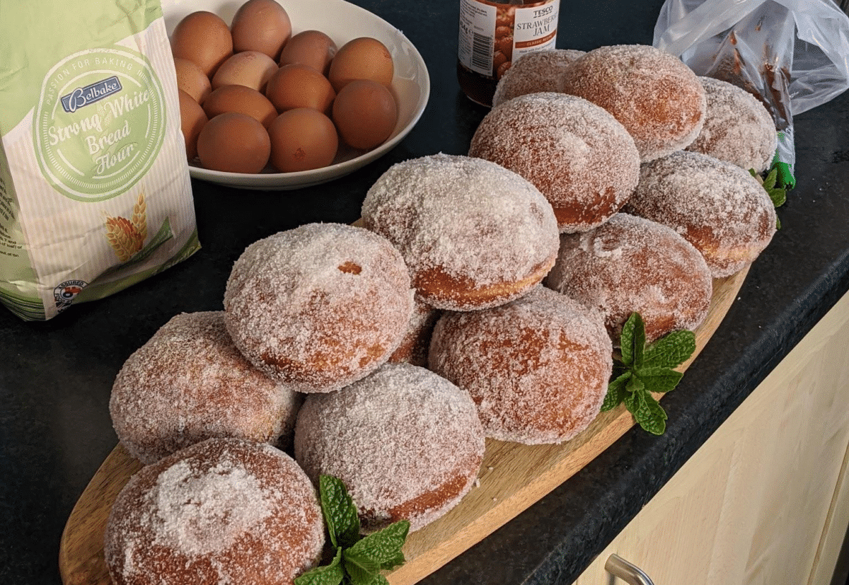Assorted yeast doughnuts with baking ingredients.