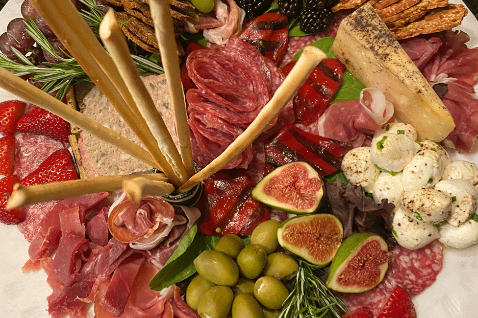 Elaborate charcuterie arrangement with cheeses, fruits, and cured meats.