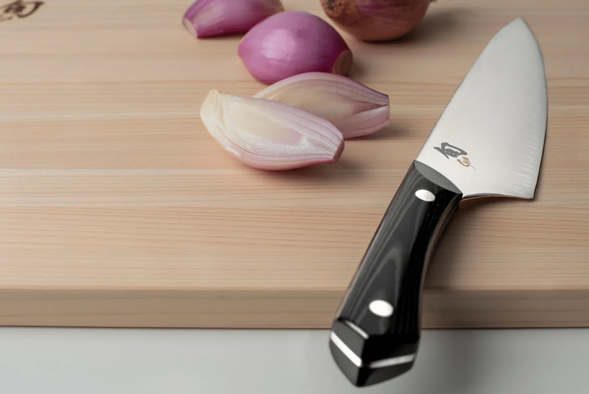Narukami Carbon Steel knife on a cutting board with red onions