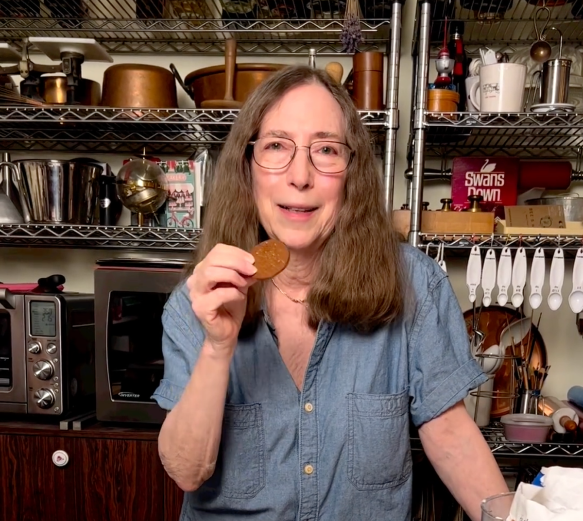 Rose Levy Berenbaum eating a cookie in her kitchen