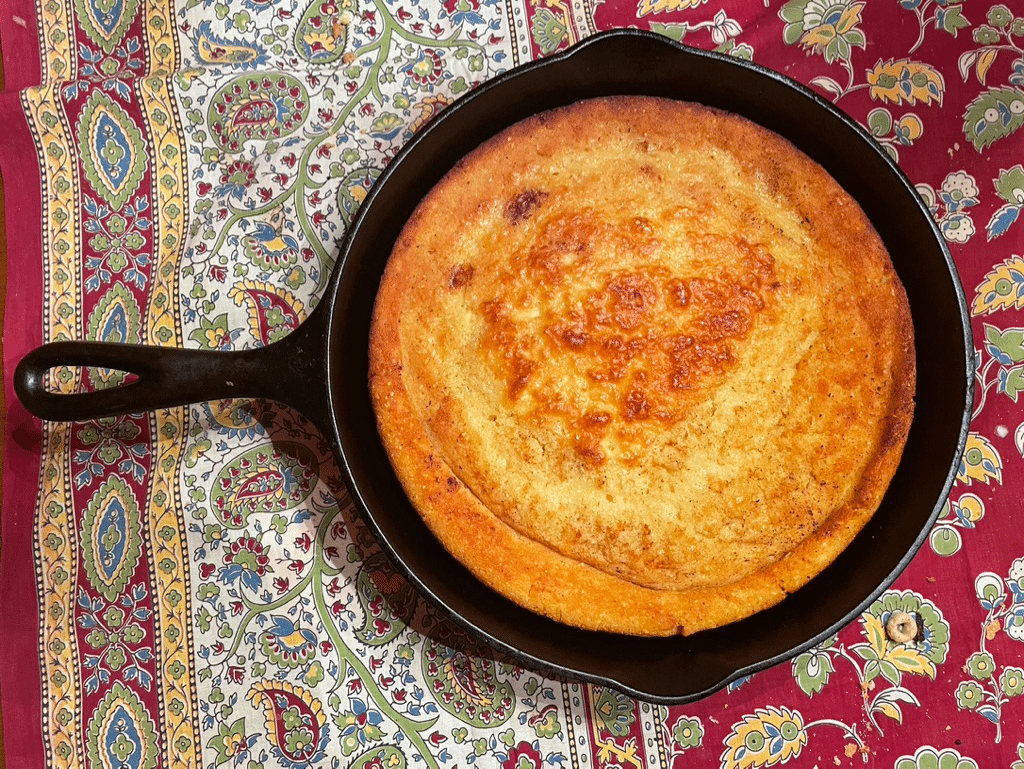 Sourdough Cast-iron skillet Cornbread on a red flowered tablecloth