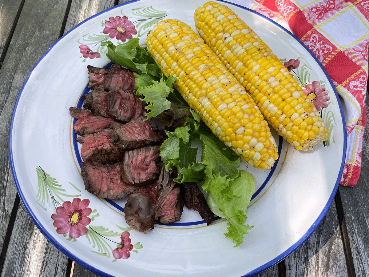 steak tips and corn on the cob on a plate